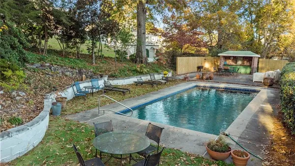 a view of house with swimming pool and outdoor seating