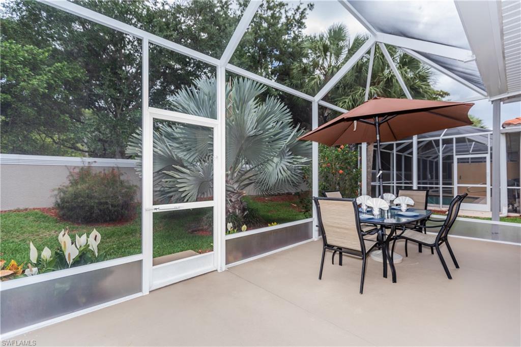 14151 Fall Creek Court Naples, FL 34114 - Photo 11 of 35 a patio with yard glass top table and chairs