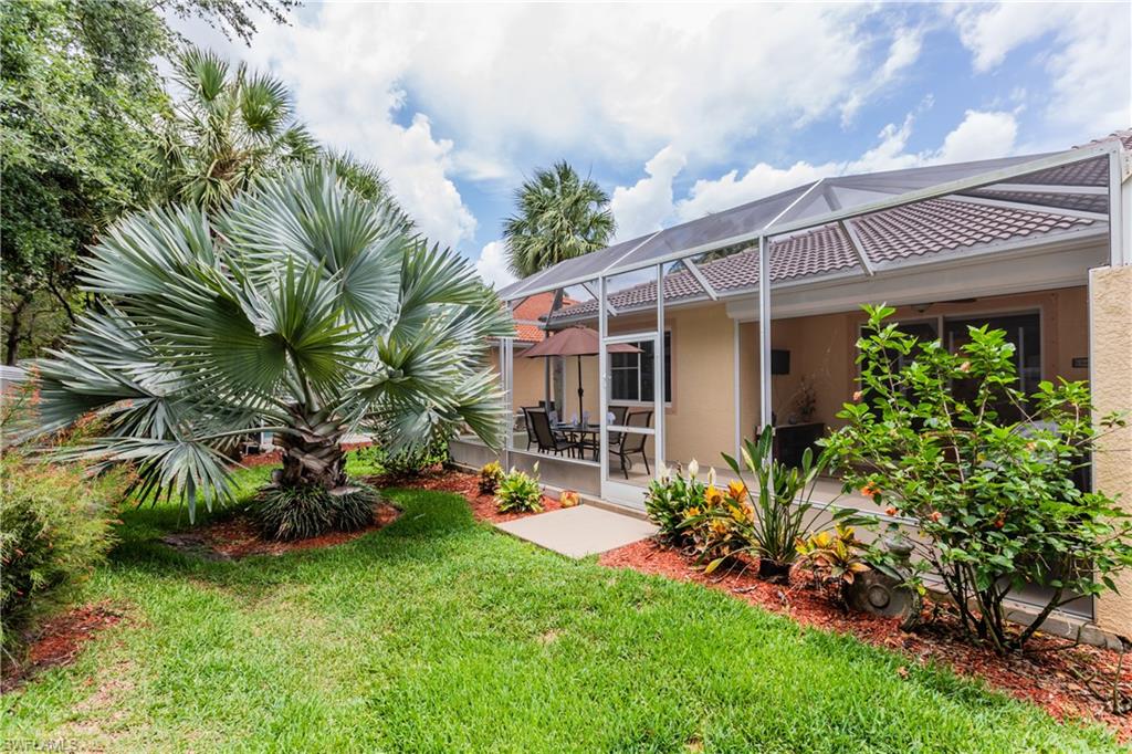 14151 Fall Creek Court Naples, FL 34114 - Photo 12 of 35 a view of a house with a backyard and a patio