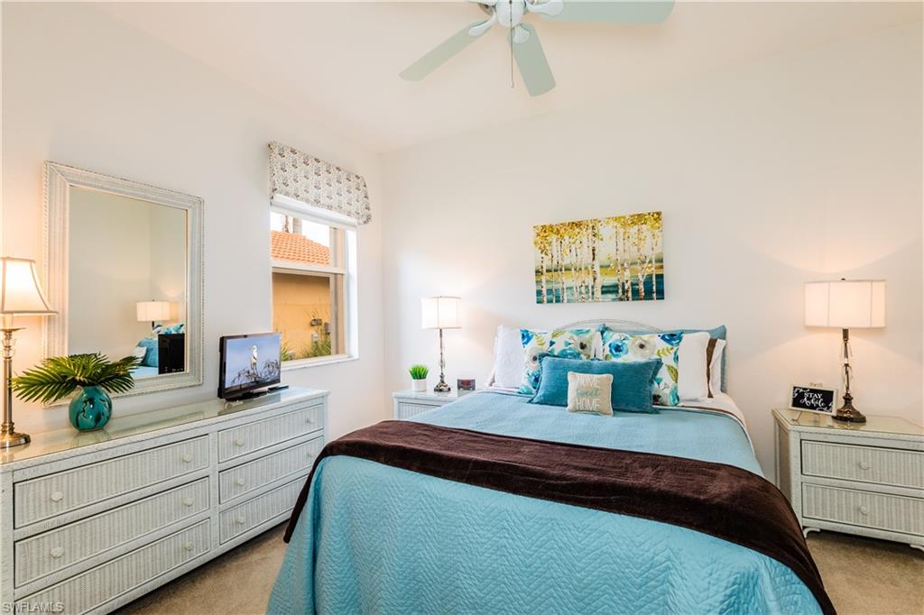 14151 Fall Creek Court Naples, FL 34114 - Photo 15 of 35 a bedroom with a large bed and a potted plant