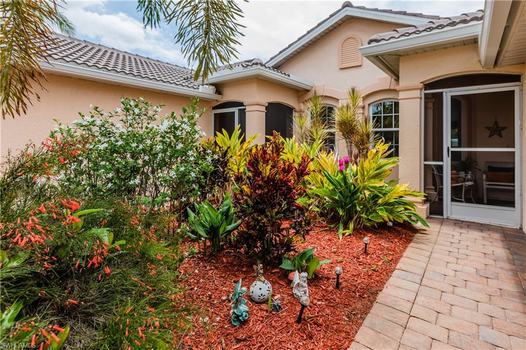 14151 Fall Creek Court Naples, FL 34114 - Photo 3 of 35 a front view of a house with garden