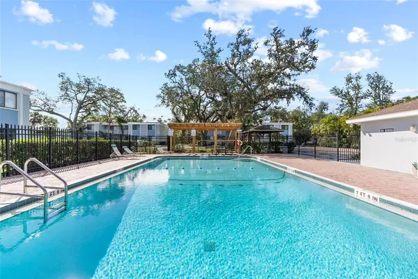 a view of a swimming pool with a patio and a yard
