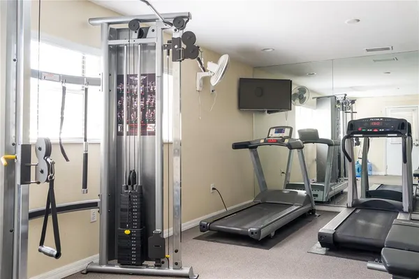 a room with gym equipment and large mirror