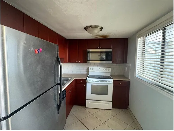 a kitchen with stainless steel appliances granite countertop a refrigerator sink and stove