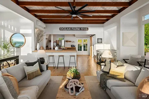 a living room with furniture and a large window with garden view