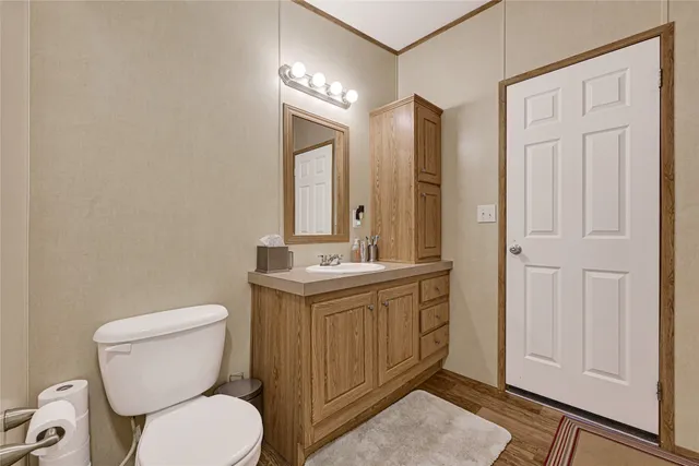 a bathroom with a toilet a sink and mirror