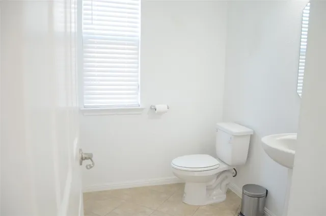 an empty room with potted plants and a window