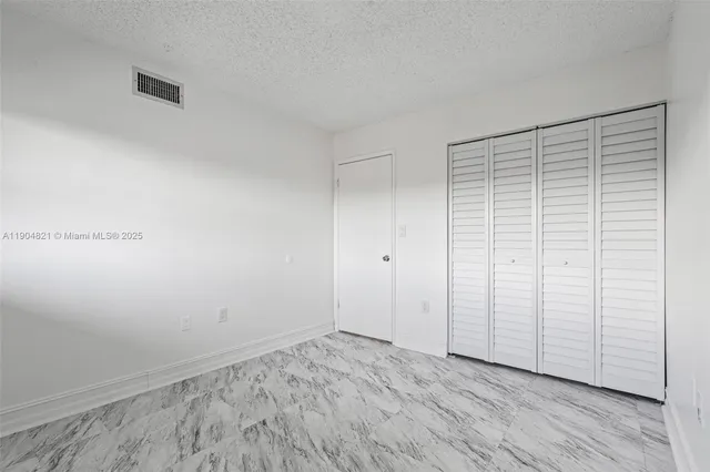 an empty room with wooden floor and white walls