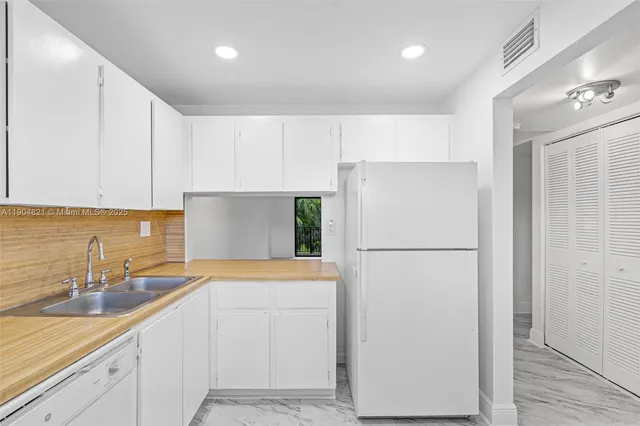 a white refrigerator freezer sitting inside of a kitchen