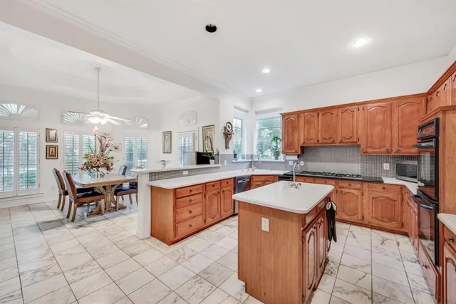a kitchen with granite countertop a stove a sink dishwasher and cabinets with wooden floor