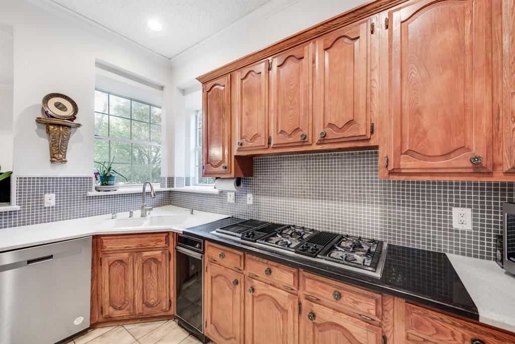 7204 Debbe Drive Dallas, TX 75252 - Photo 15 of 40 a kitchen with granite countertop a stove a sink dishwasher and cabinets with wooden floor