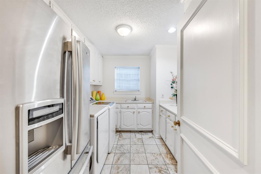 7204 Debbe Drive Dallas, TX 75252 - Photo 21 of 40 a kitchen with a refrigerator and a sink