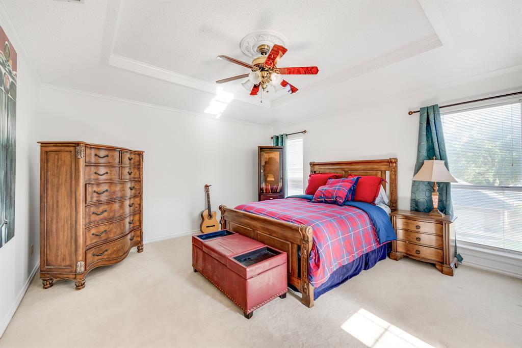 7204 Debbe Drive Dallas, TX 75252 - Photo 36 of 40 a bedroom with a bed and a chandelier