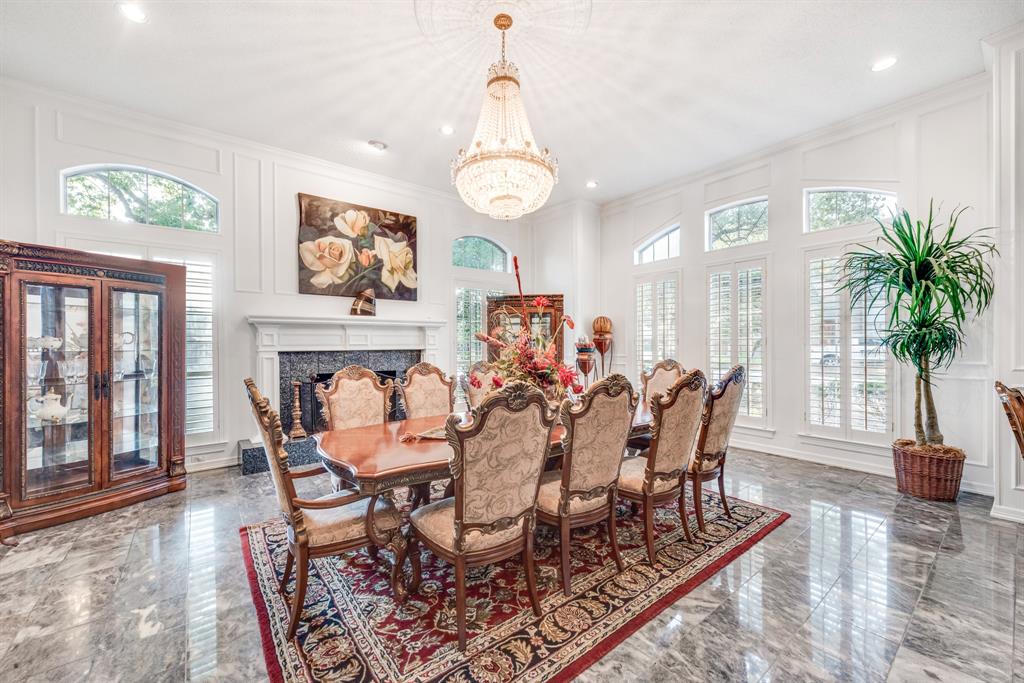 7204 Debbe Drive Dallas, TX 75252 - Photo 8 of 40 a dining room with wooden floor a chandelier a wooden table and chairs