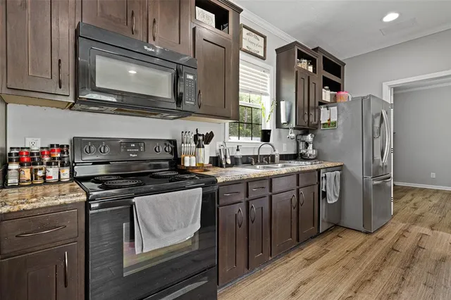 a kitchen with stainless steel appliances granite countertop a refrigerator stove and sink