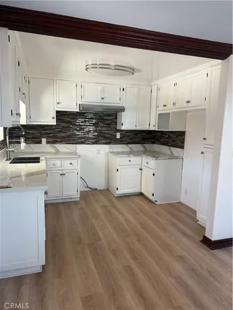 a kitchen with granite countertop a sink and cabinets