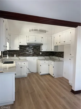 a kitchen with granite countertop white cabinets and white appliances
