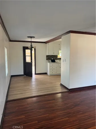 a view of a kitchen with wooden floor and a refrigerator