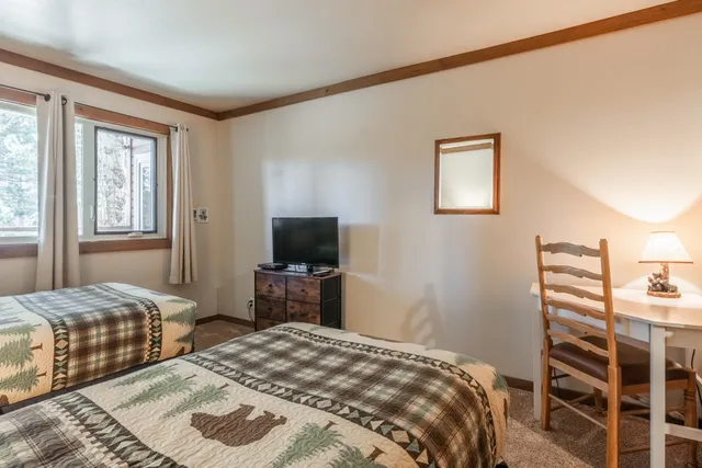 a bedroom with two beds and a large window