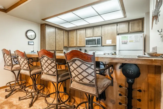 a balcony with couple of chairs and a rug