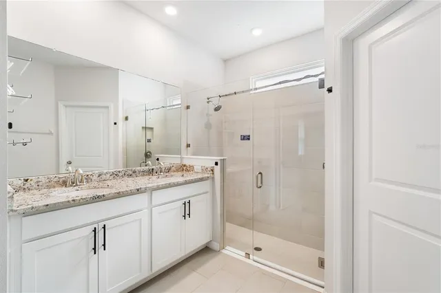 a bathroom with a granite countertop sink a mirror a shower and a bathtub