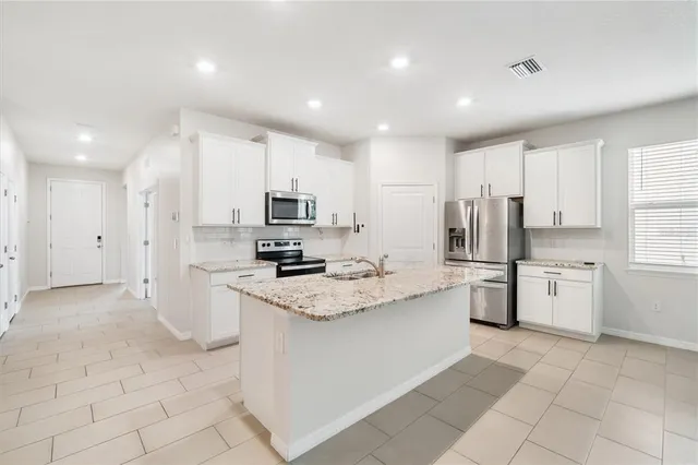 a kitchen with stainless steel appliances a refrigerator sink and microwave