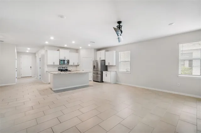 a view of kitchen with kitchen island white cabinets and refrigerator