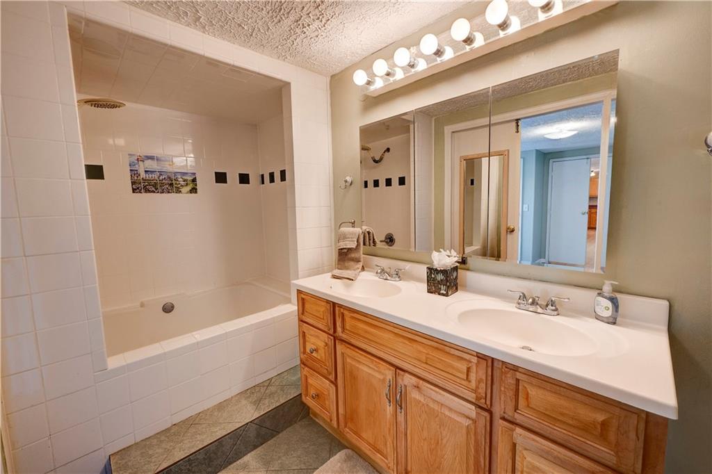 960 McEntyre Loop Calhoun, GA 30701 - Photo 34 of 77 a bathroom with a sink double vanity granite tub shower and a mirror