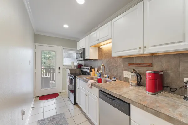 a kitchen with stainless steel appliances granite countertop a sink dishwasher stove and refrigerator