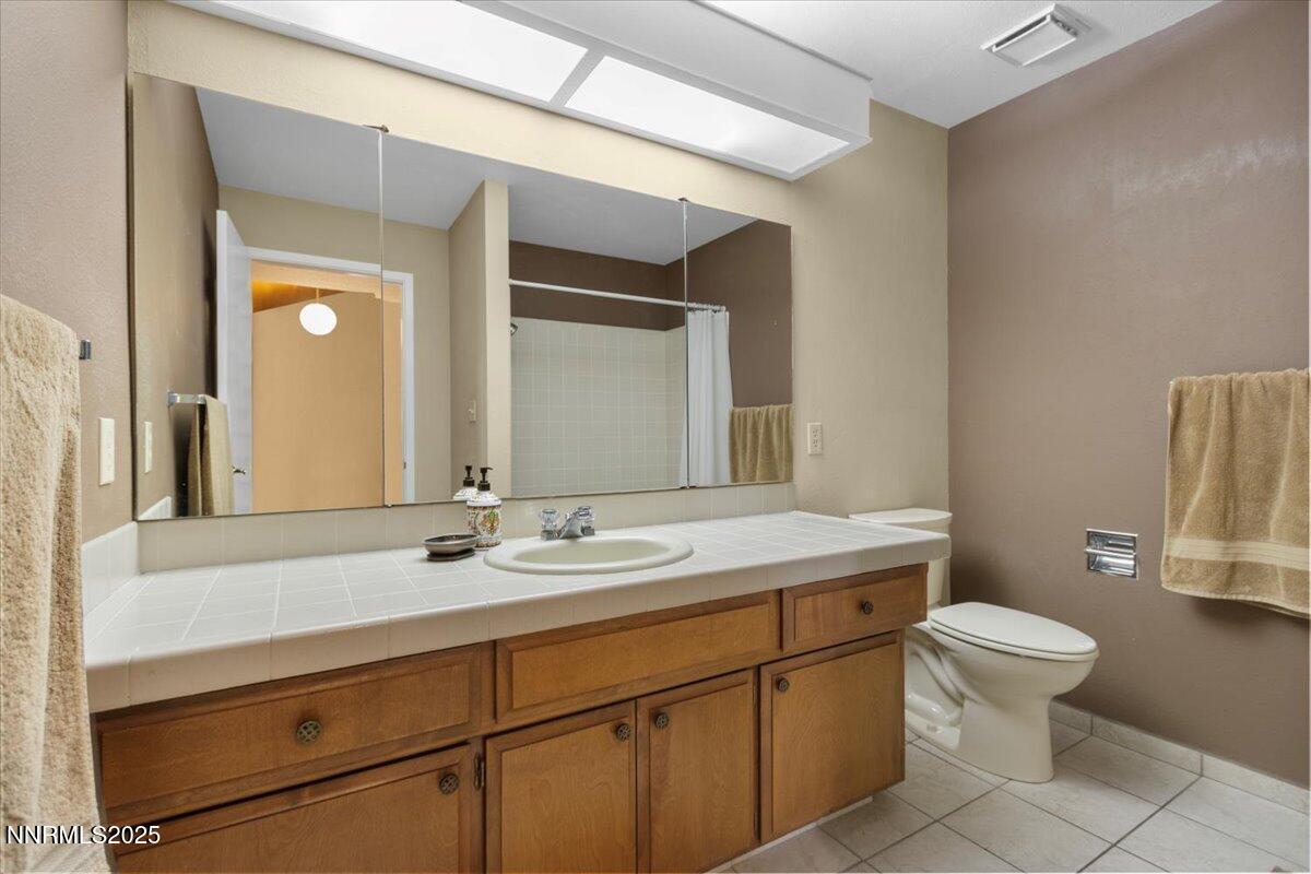 2108 Chicory Way Reno, NV 89509 - Photo 14 of 21 a bathroom with a sink a toilet a mirror and vanity