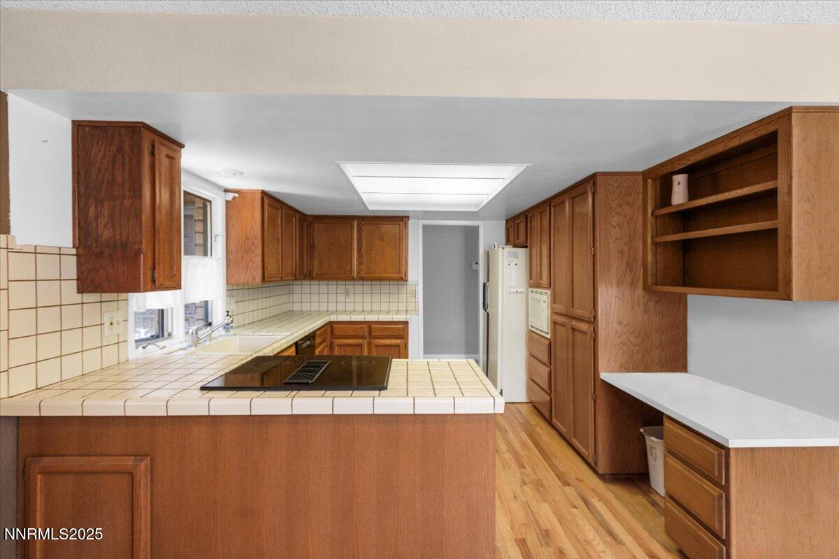 2108 Chicory Way Reno, NV 89509 - Photo 5 of 21 a kitchen with a sink a stove cabinets and a wooden floor