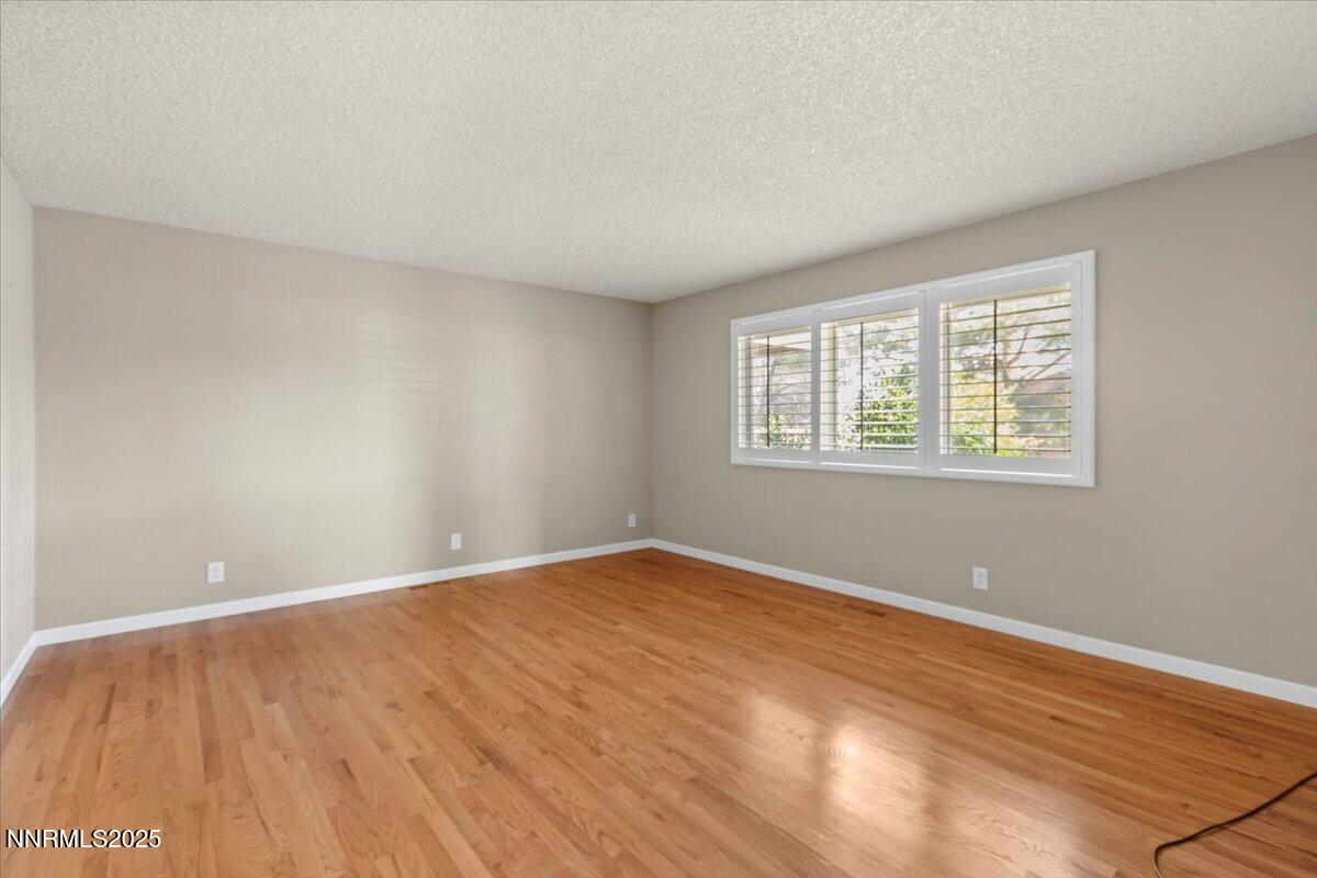 2108 Chicory Way Reno, NV 89509 - Photo 8 of 21 a view of an empty room with wooden floor and a window