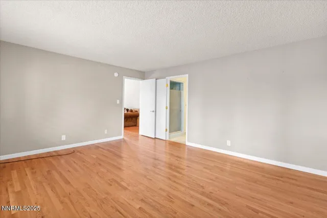 a view of an empty room with wooden floor