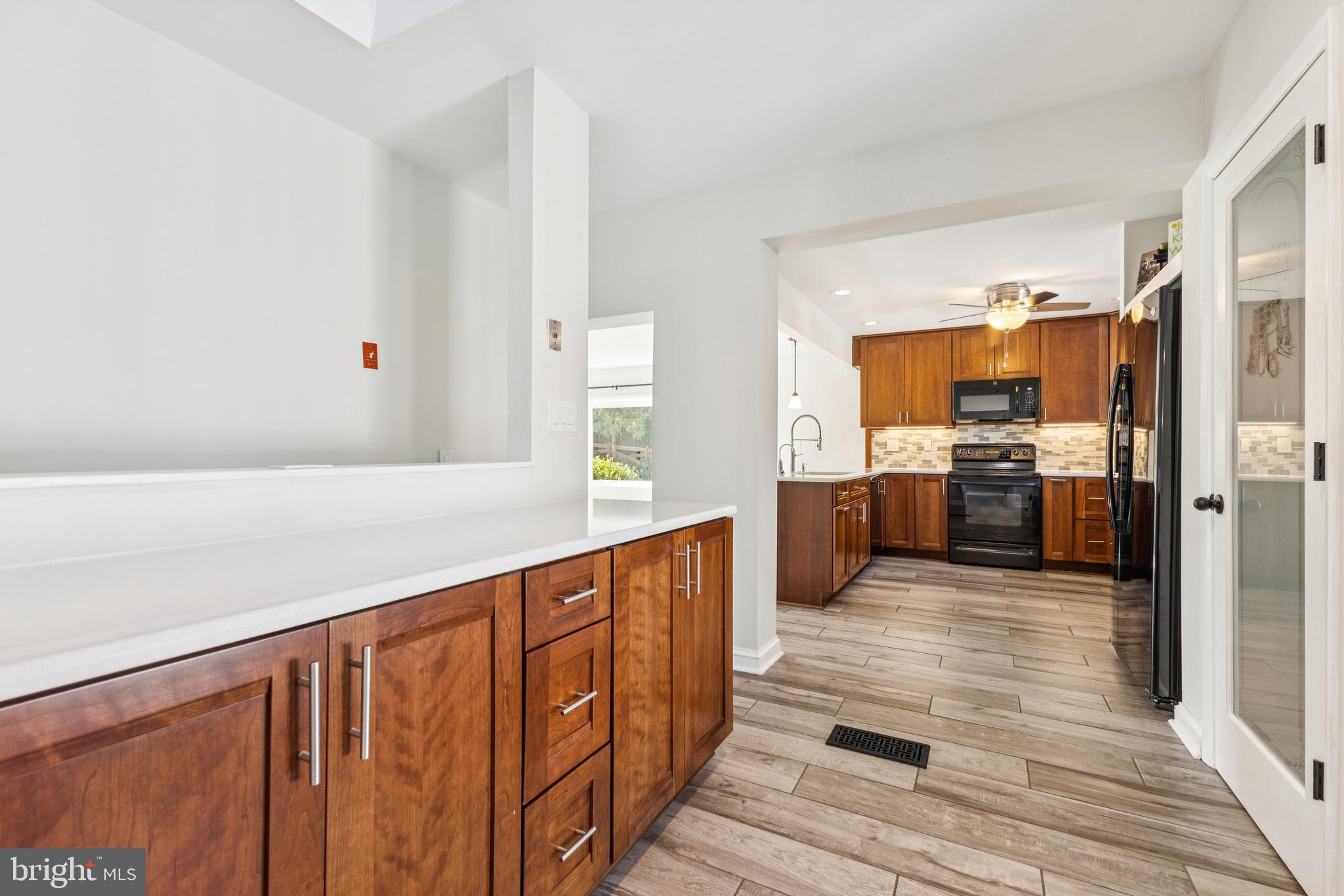 22810 Ridge Road Clarksburg, MD 20871 - Photo 15 of 44 a large kitchen with stainless steel appliances wooden cabinets and wooden floor