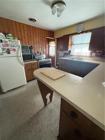 a kitchen with kitchen island a stove a sink dishwasher and a refrigerator