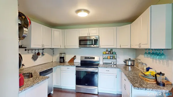 a kitchen with stainless steel appliances granite countertop a stove a microwave and a refrigerator