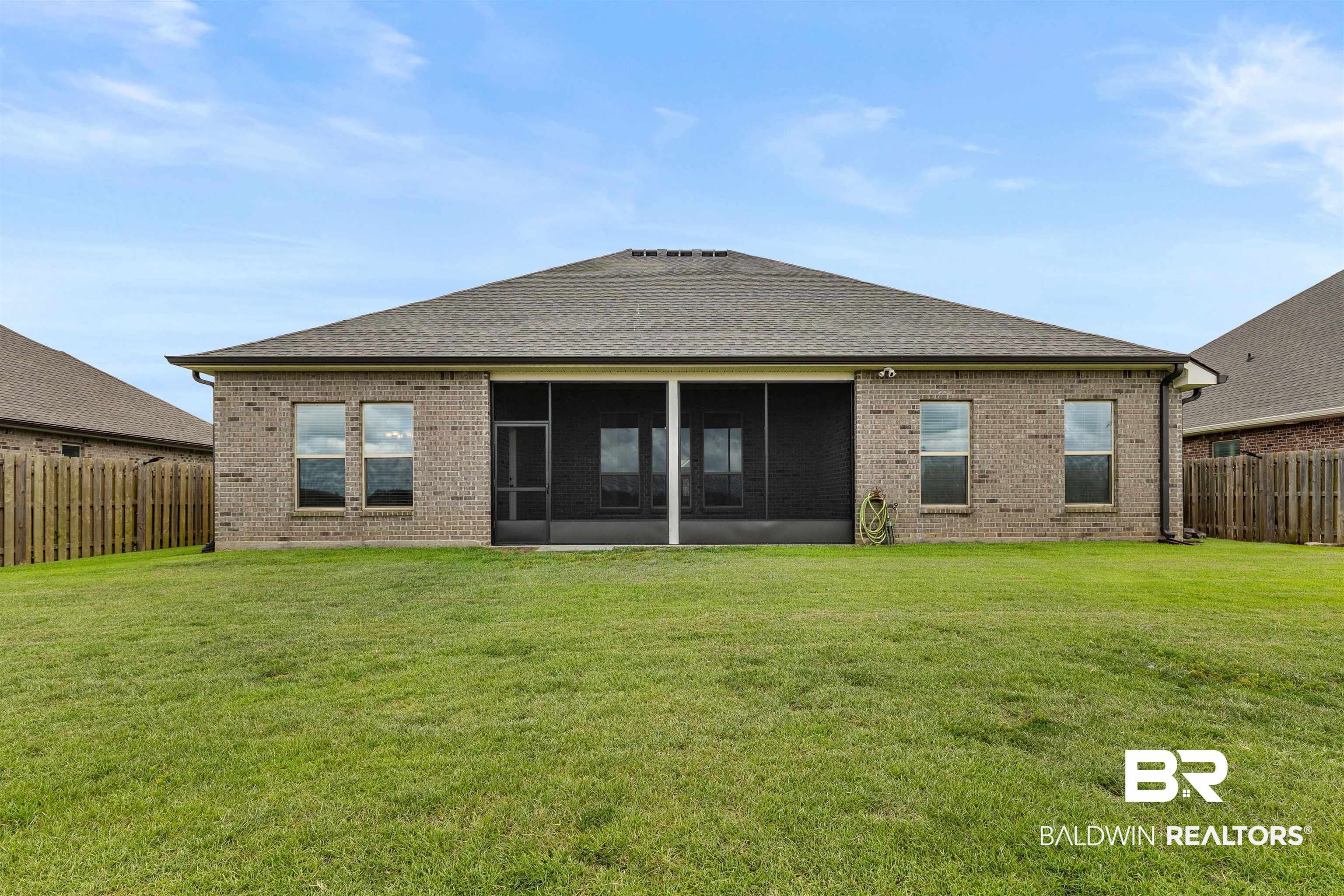 991 Dalton Circle Foley, AL 36535 - Photo 33 of 35 Back of house featuring brick siding, a sunroom, a fenced backyard, and a shingled roof
