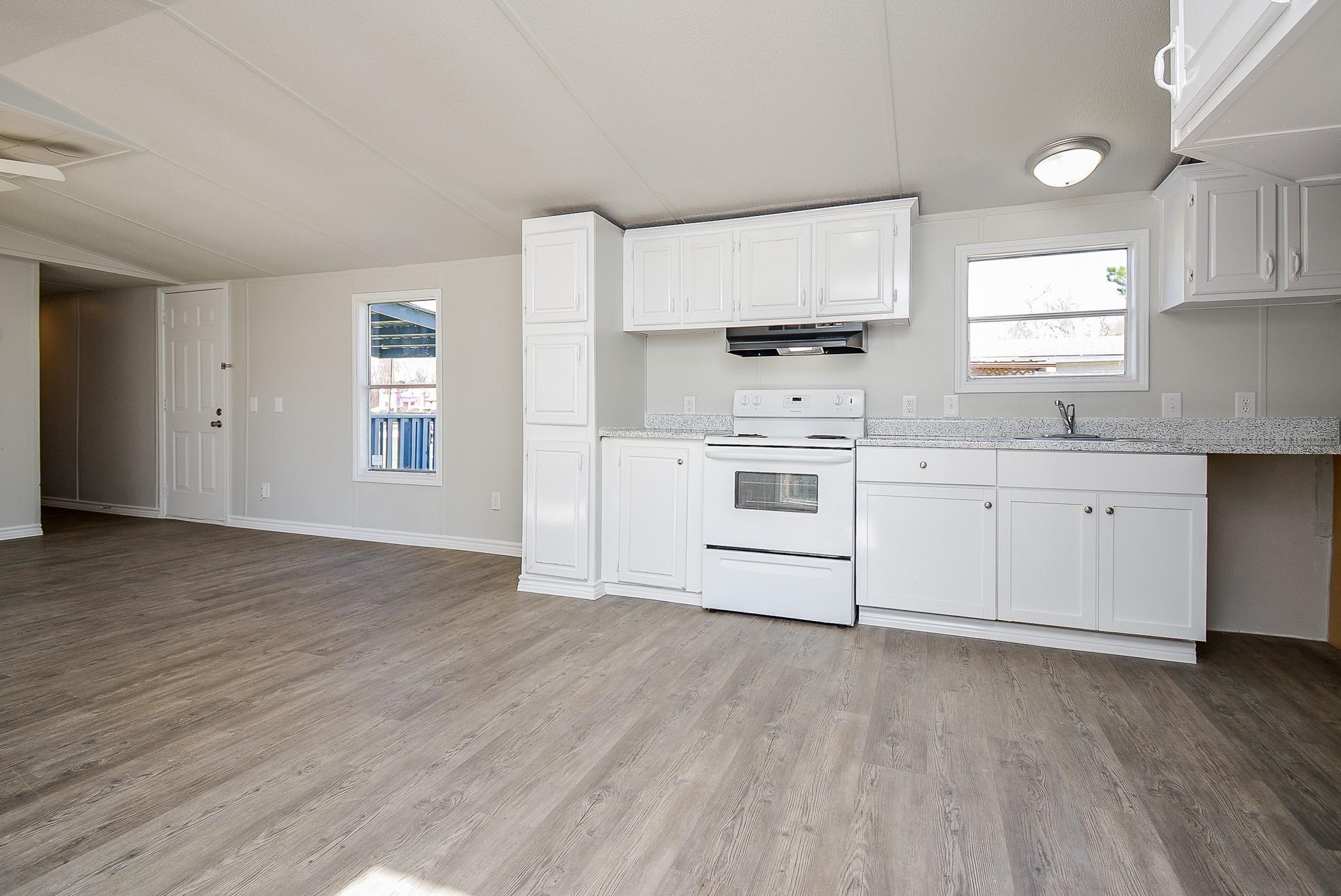 12561 Roy Harris Loop Conroe, TX 77306 - Photo 14 of 31 a kitchen with stainless steel appliances a white cabinets and wooden floor