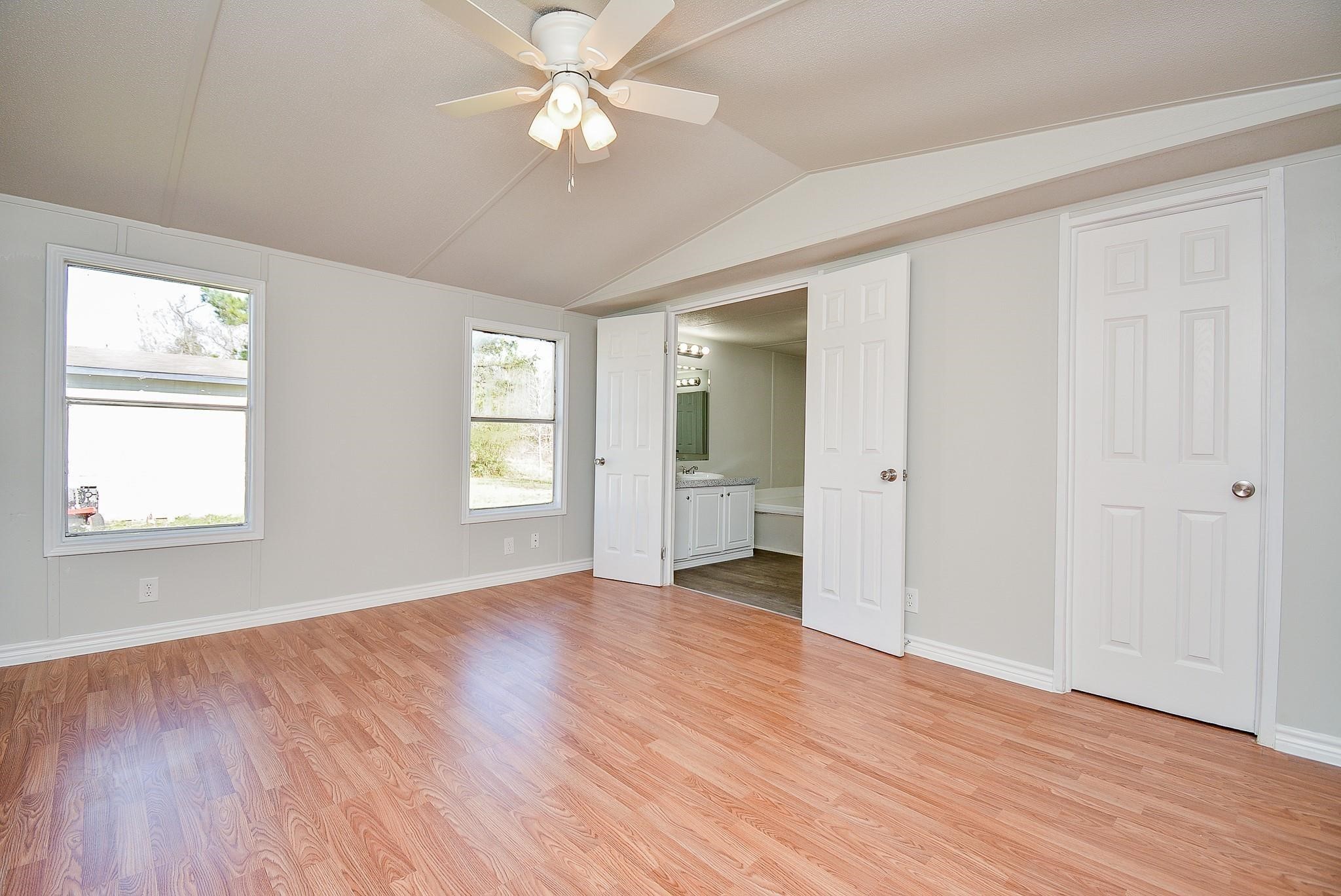12561 Roy Harris Loop Conroe, TX 77306 - Photo 16 of 31 a view of an empty room with a window and wooden floor