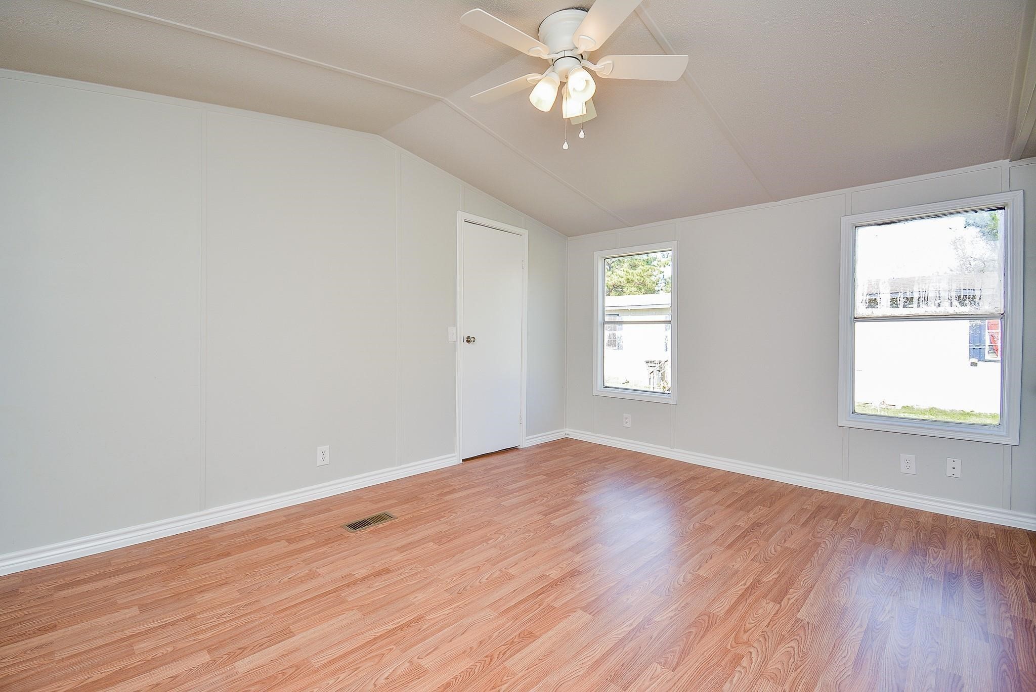 12561 Roy Harris Loop Conroe, TX 77306 - Photo 19 of 31 wooden floor in an empty room with a window