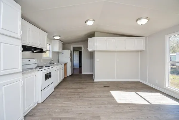 a kitchen with white cabinets and white appliances