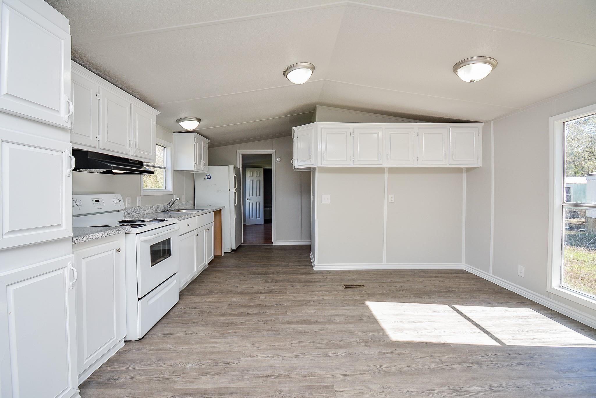 12561 Roy Harris Loop Conroe, TX 77306 - Photo 10 of 31 a kitchen with white cabinets and white appliances