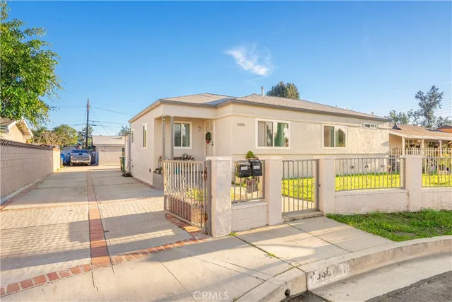 a front view of a house with a yard and potted plants
