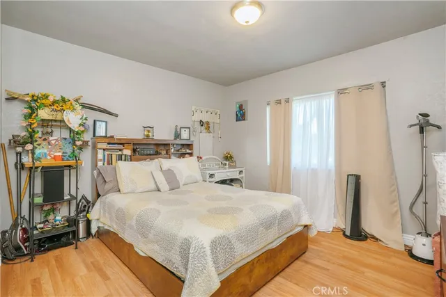 a bedroom with a bed and a flat tv screen on dresser