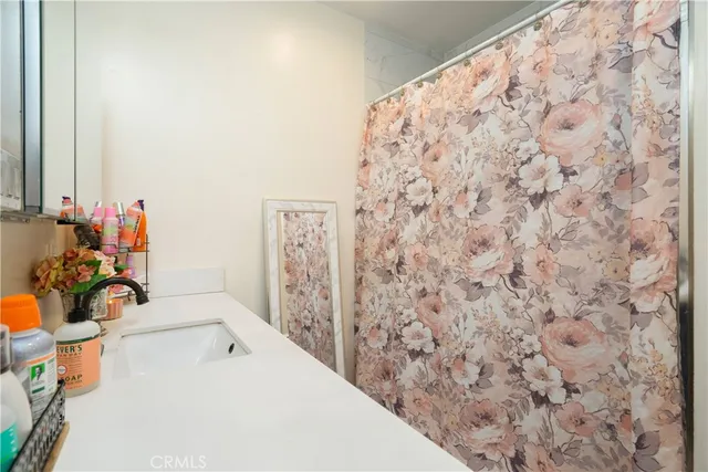 a kitchen with stainless steel appliances granite countertop a refrigerator a stove a sink and white cabinets with wooden floor