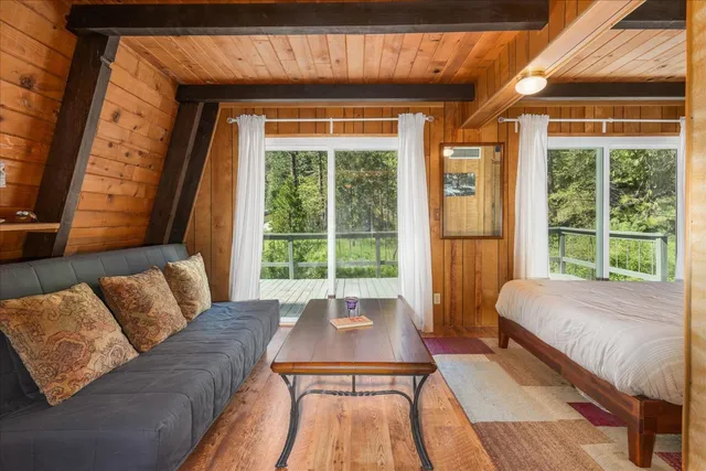 a living room with a bed and a large window