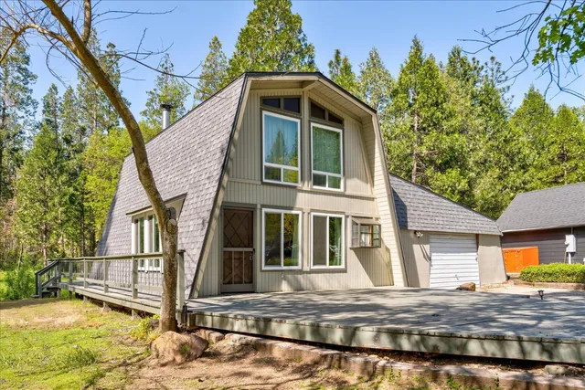 a view of a house with wooden fence next to a yard