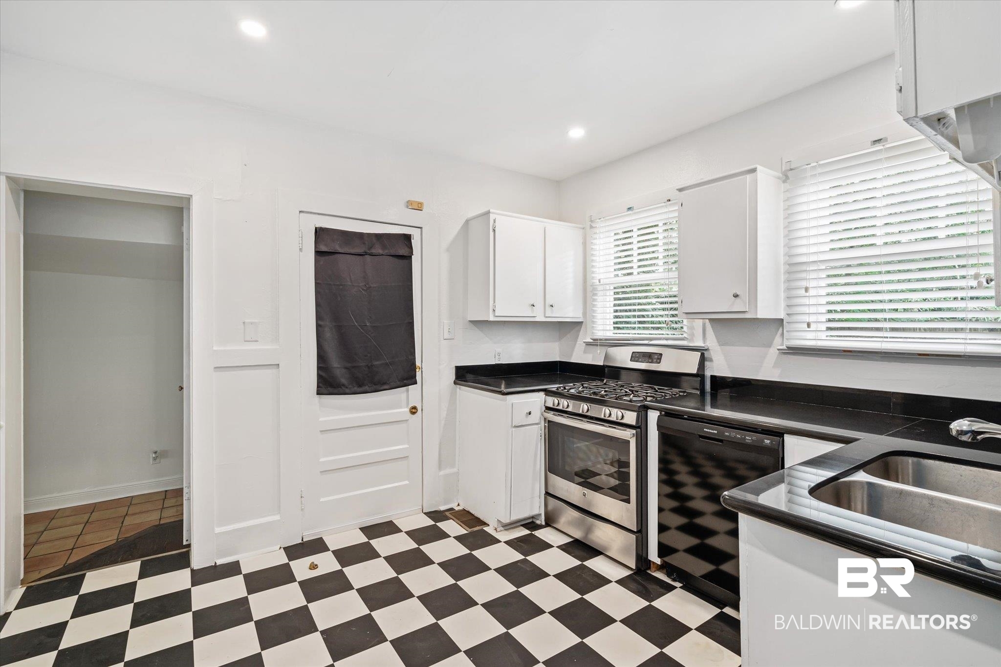 1159 Palmetto Street Mobile, AL 36604 - Photo 8 of 21 Kitchen featuring light tile patterned flooring, white cabinetry, stainless steel range with gas cooktop, sink, and dishwasher