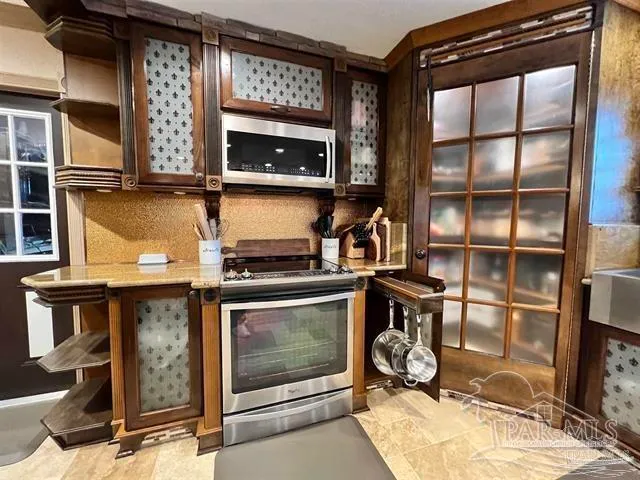 a kitchen with stainless steel appliances granite countertop a stove a sink and a refrigerator