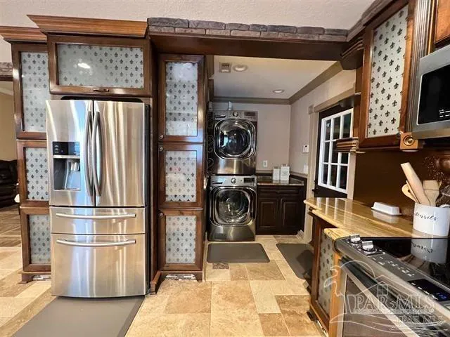 a view of a kitchen with stainless steel appliances granite countertop a refrigerator and a stove top oven